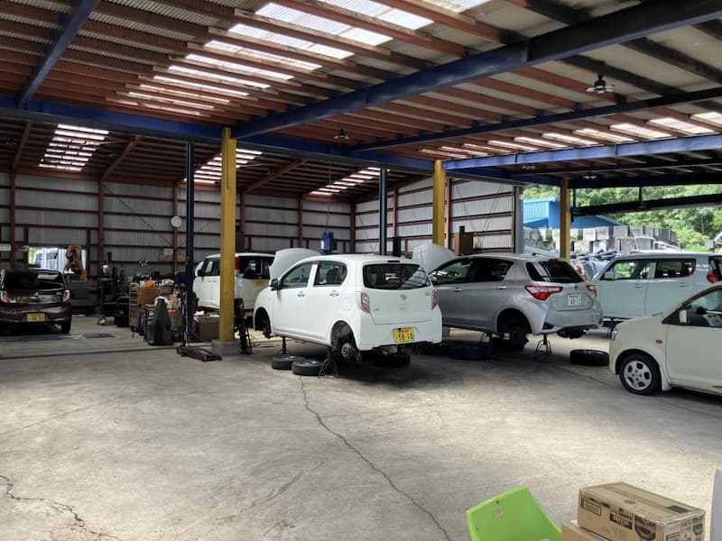 社屋の整備工場内に並ぶ白とグレーの車両たち